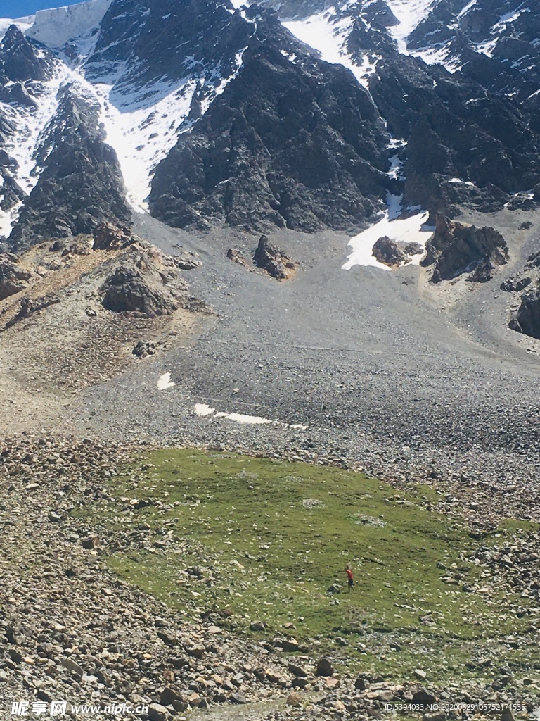 渺小的登山者在雪山下面