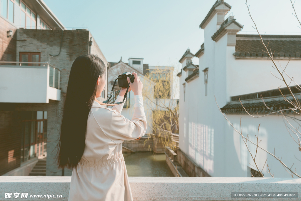 青春美女大学生背着相机旅行拍照