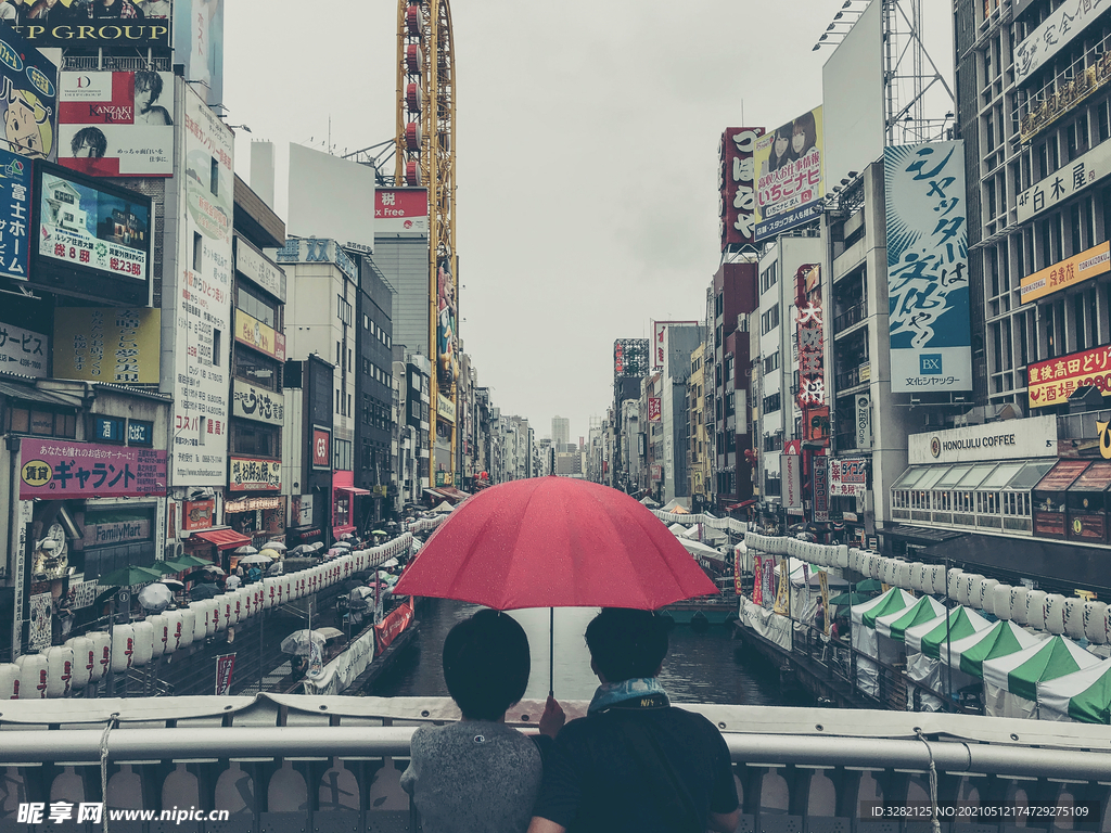 日本大阪道顿堀打着红伞的情侣
