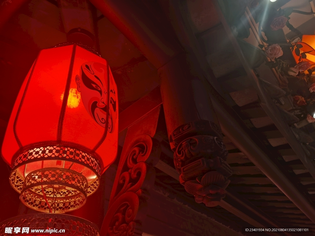 中式建筑下的红色脸谱灯笼