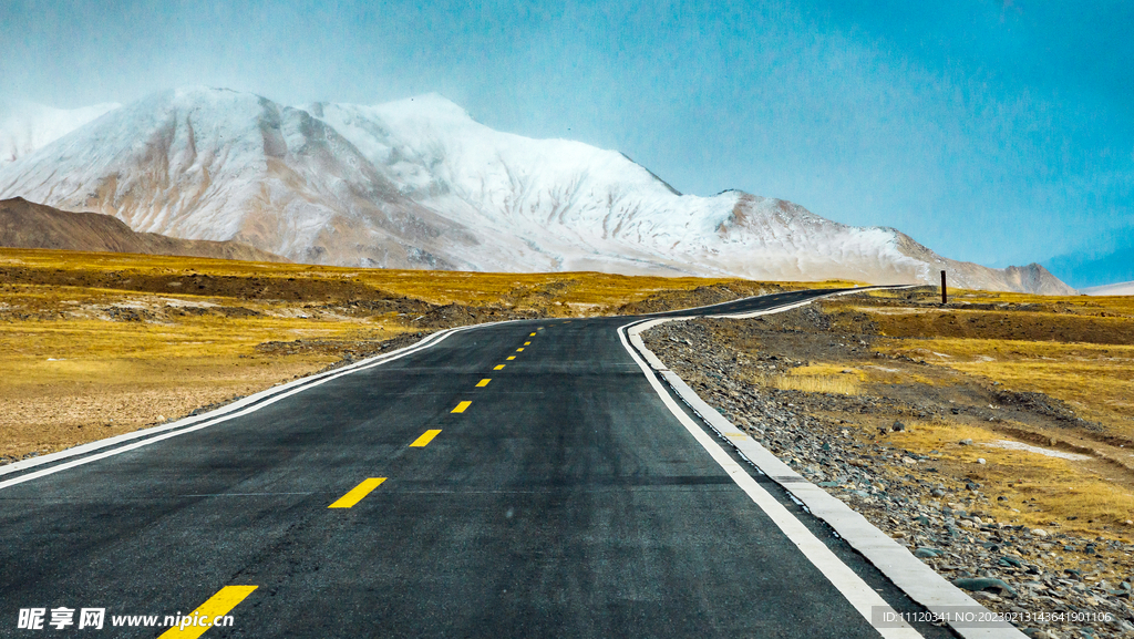 雪山下草原上的公路景观