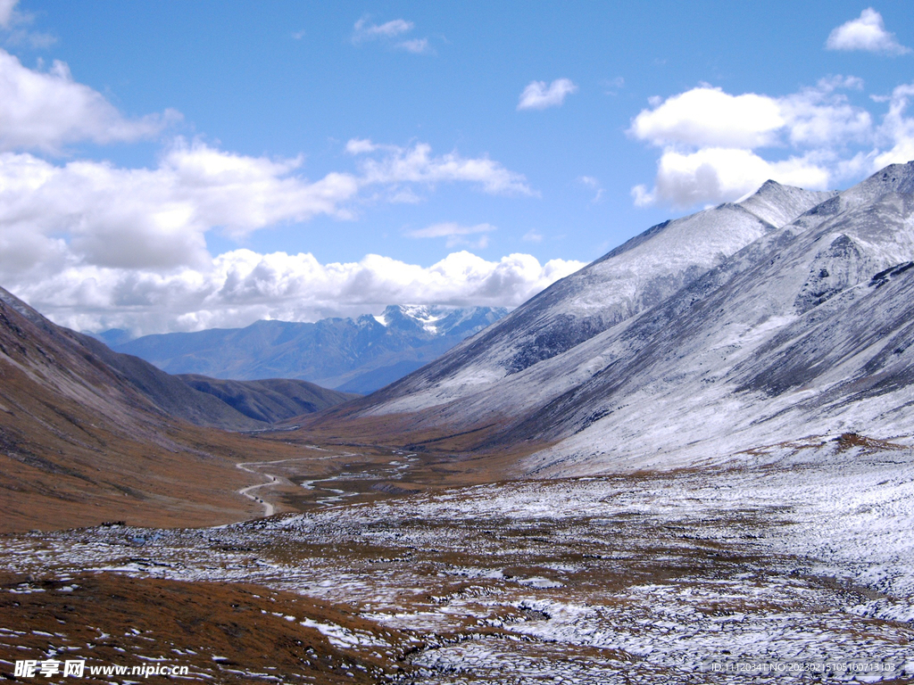 蓝天白云下的雪后山谷美景