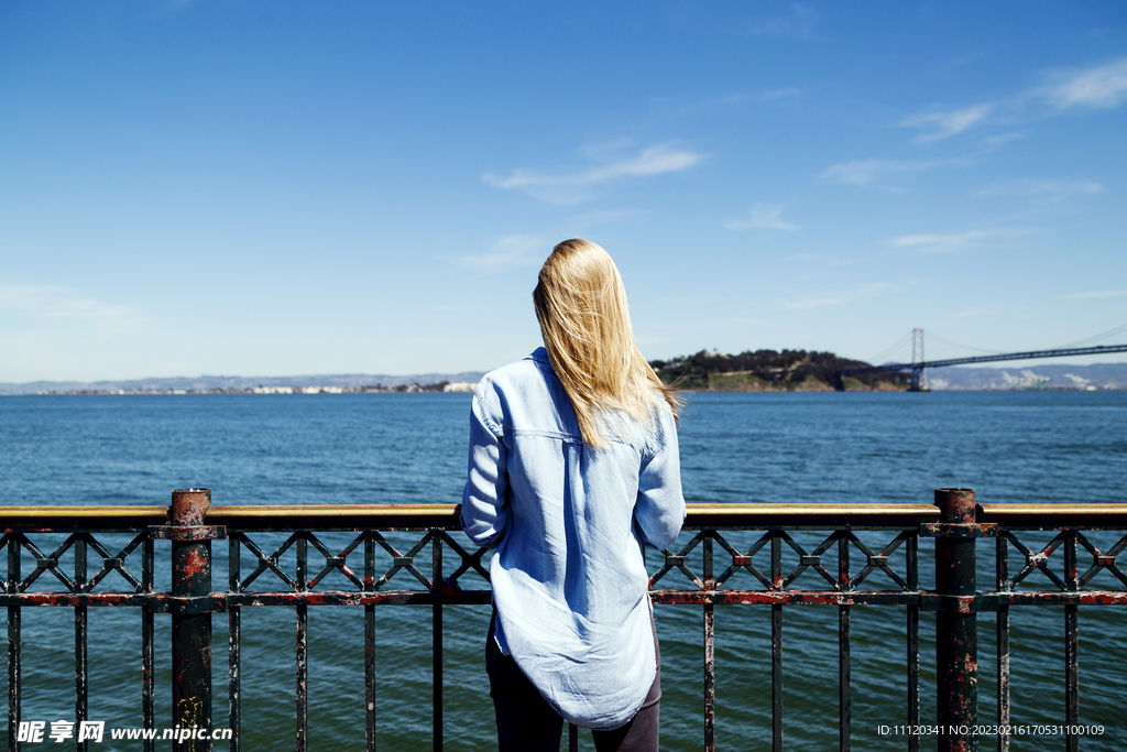 站在海边看海景的金发美女