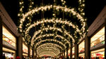 松针藤条呈弧形悬挂在商场的顶上，还有圣诞灯串也挂在一起，并排列成6排
