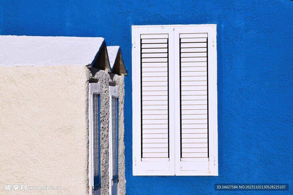 蓝色墙上的白色窗户
