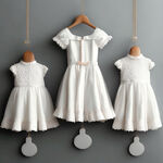 设计一套小女孩白色非常隆重的礼服，挂在白色的墙上
