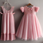 设计一套小女孩的粉色礼服，。挂在墙上。粉色的，衣服是纱纱裙
