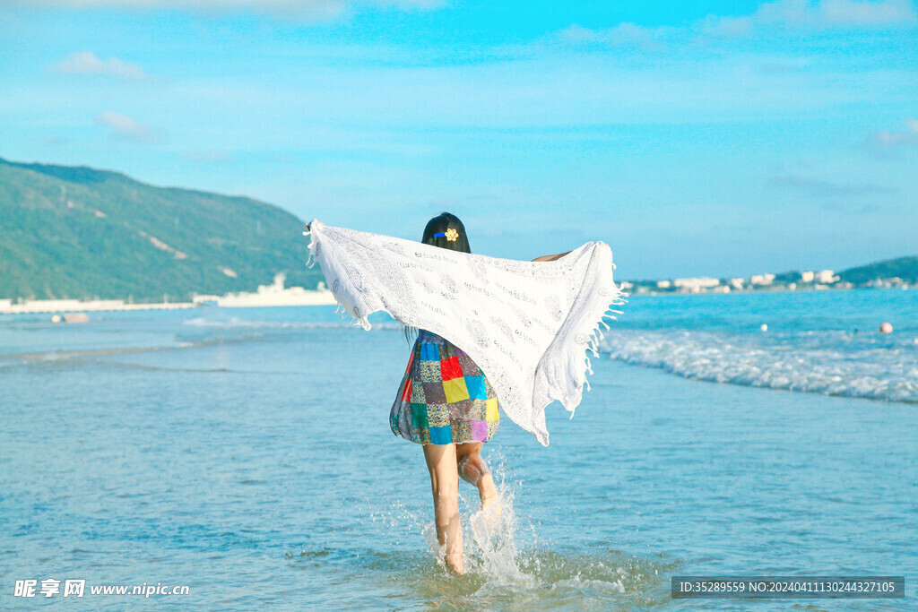 海边披着围巾沙滩上奔跑的美女