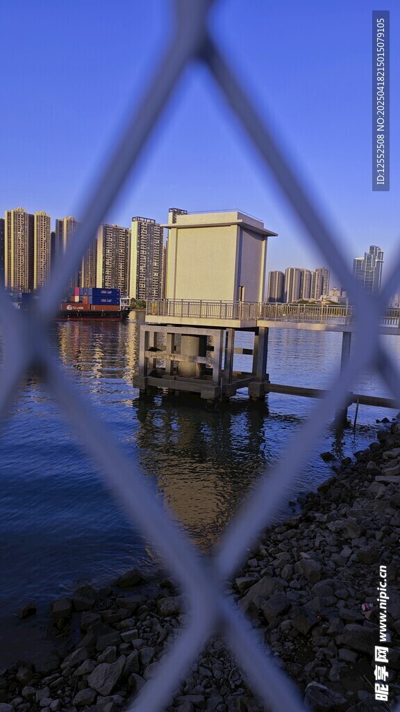 透过围栏看水边码头景象