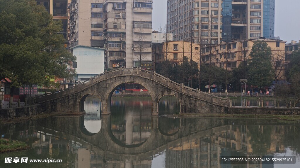 城市古桥映于平静湖水