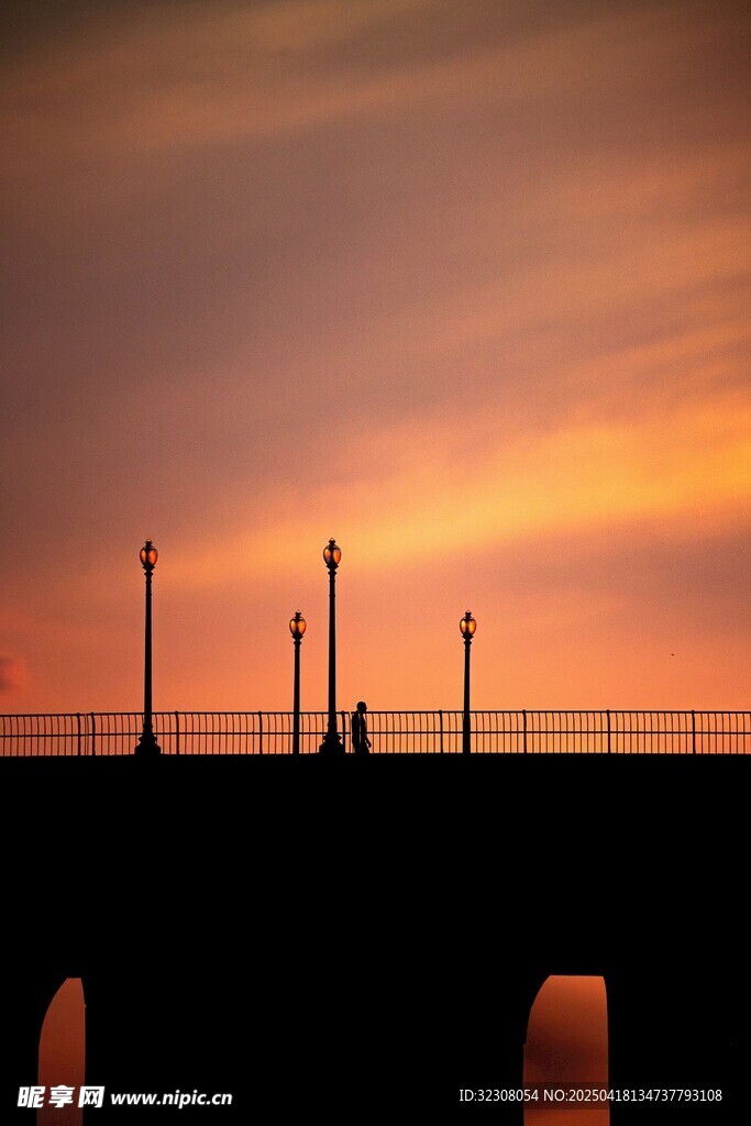 夕阳下的桥与行人剪影