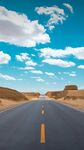 旷野公路伸向蓝天白云