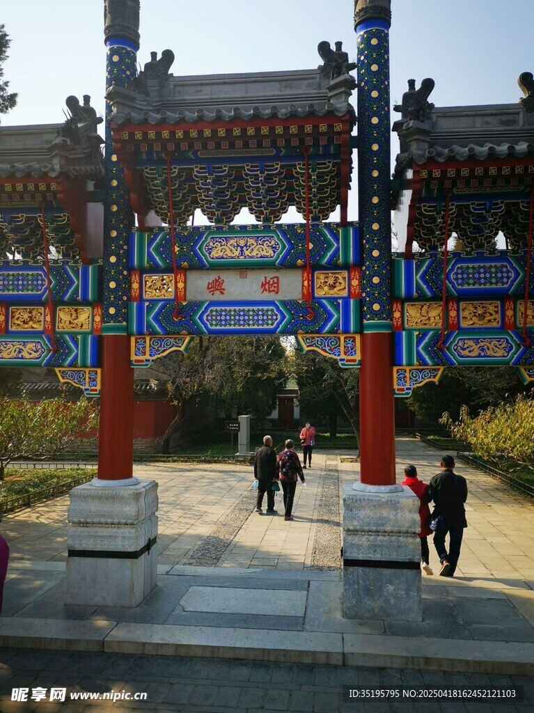 古色古香牌坊下行人漫步