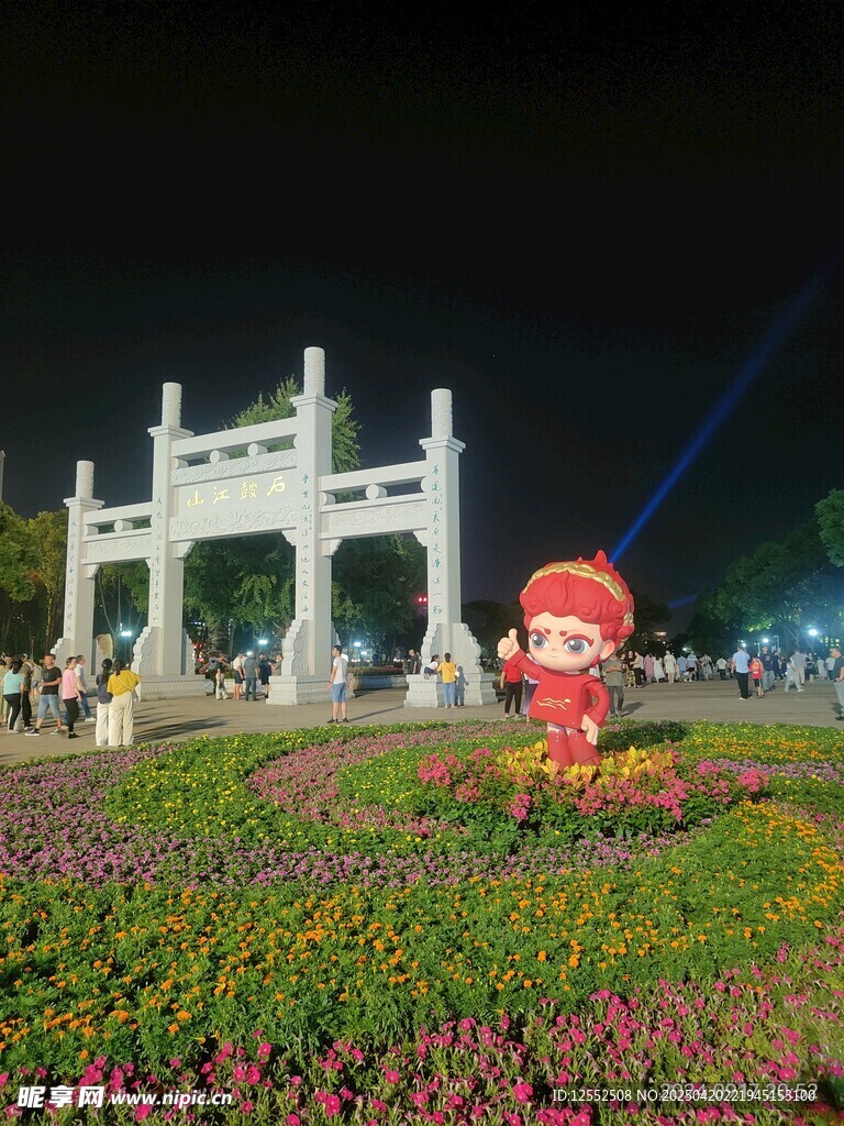 夜晚花坛旁的中式牌坊景观