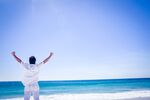 海边男子舒展双臂迎海风