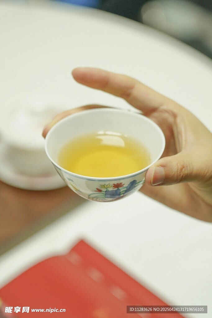 手持茶杯品茗韵