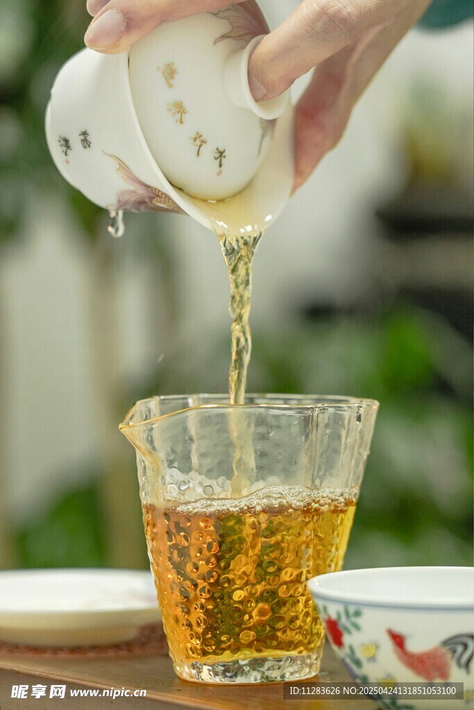 手倾壶倒茶入玻璃杯