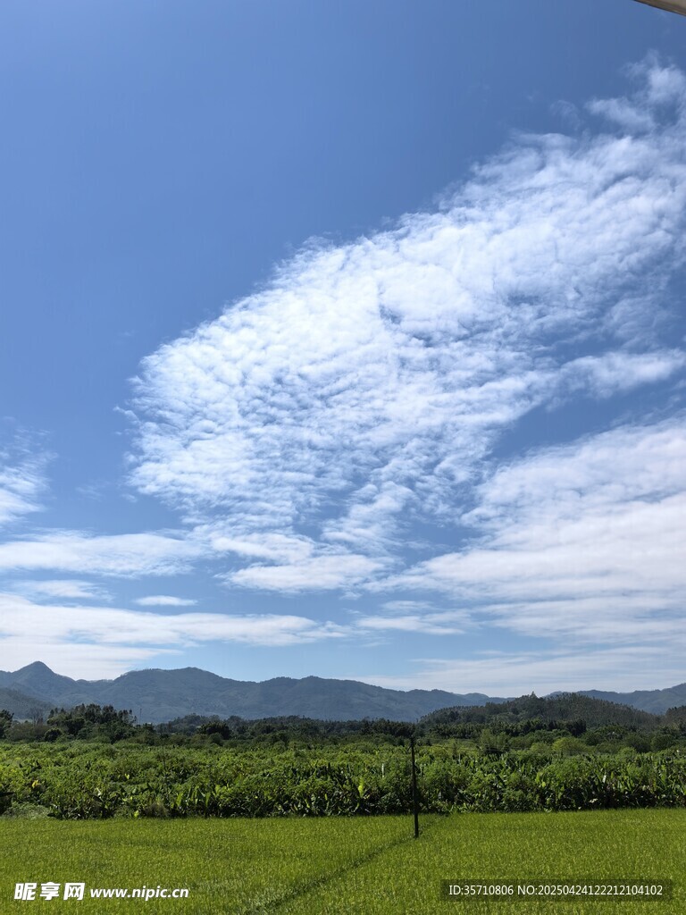 蓝天白云下的绿野山峦