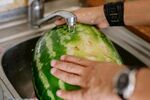 水槽中双手清洗大西瓜