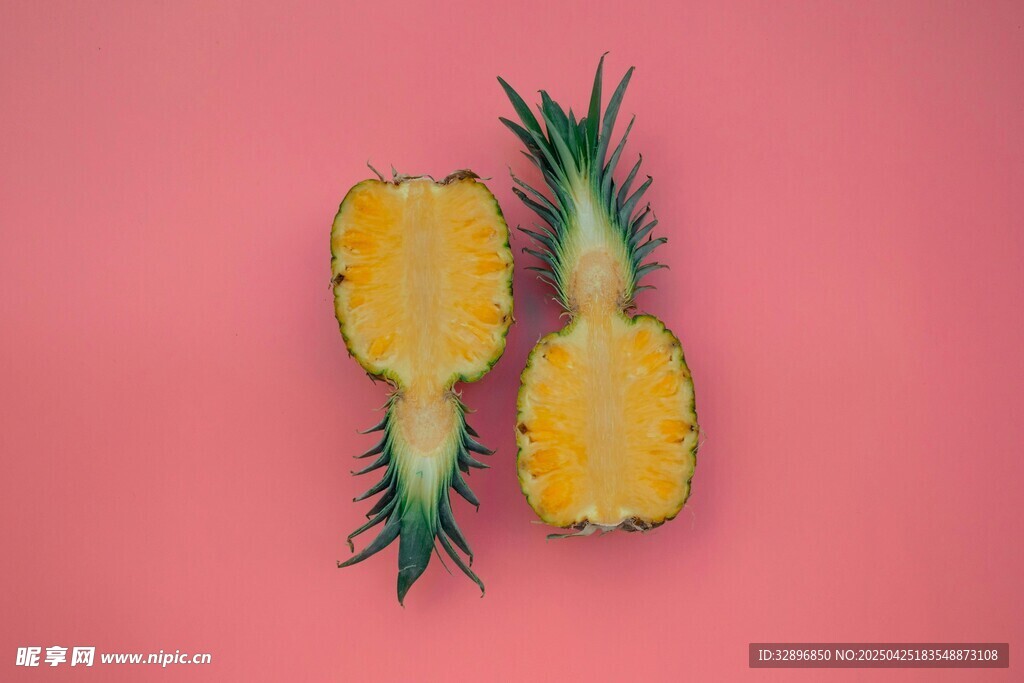 粉色背景上的两半新鲜菠萝