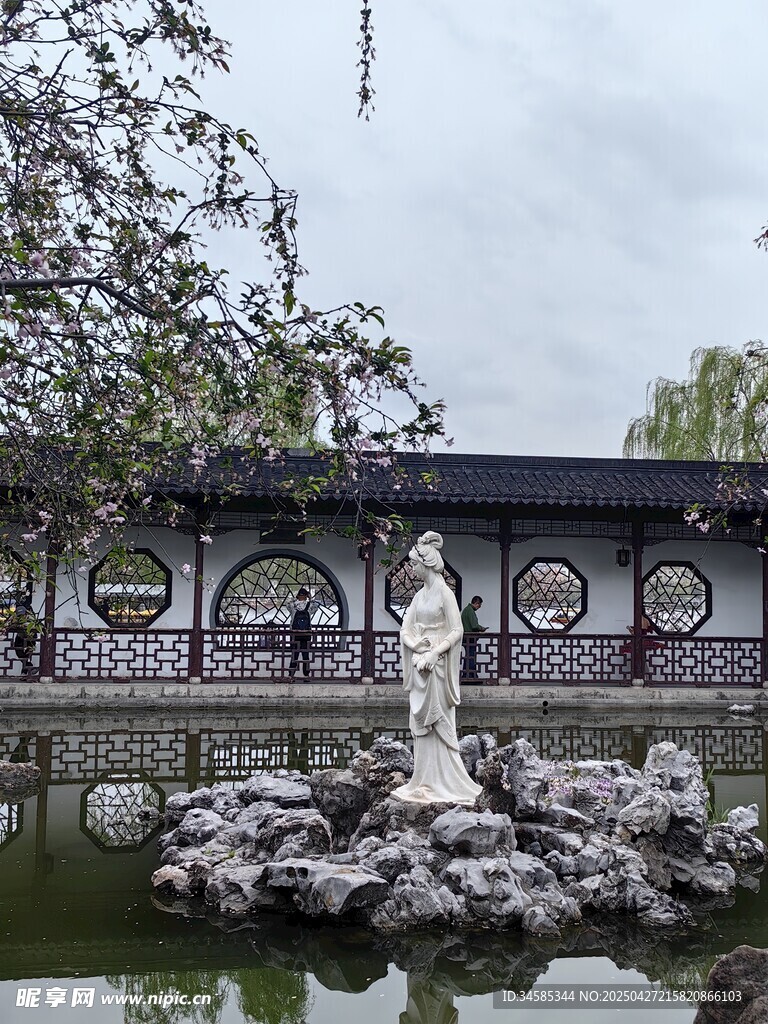 中式园林池塘中的雕像景观