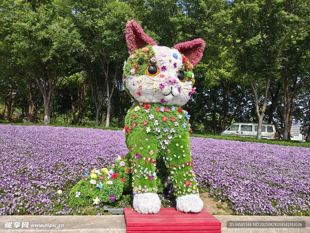 花丛中的多彩猫咪雕塑