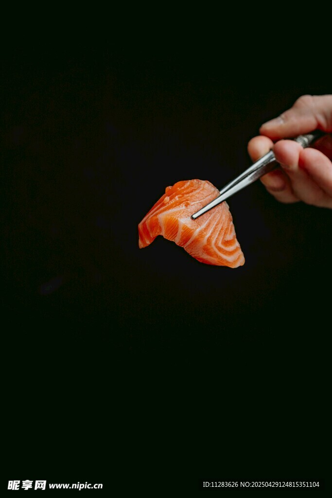 手拿筷子夹着三文鱼寿司