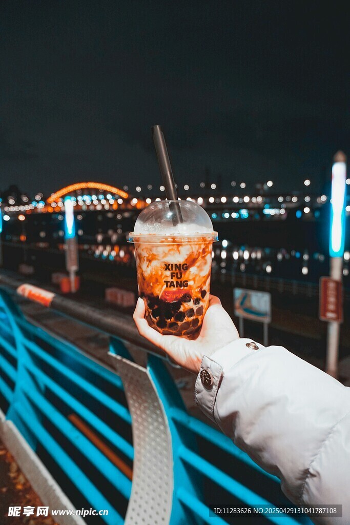 夜晚手持饮品赏城市夜景