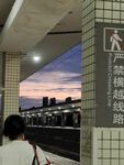 站台傍晚行人与跨越线路牌