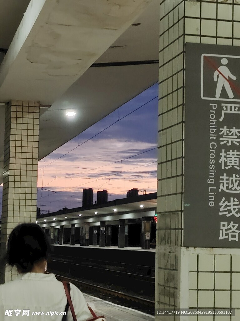 站台傍晚行人与跨越线路牌
