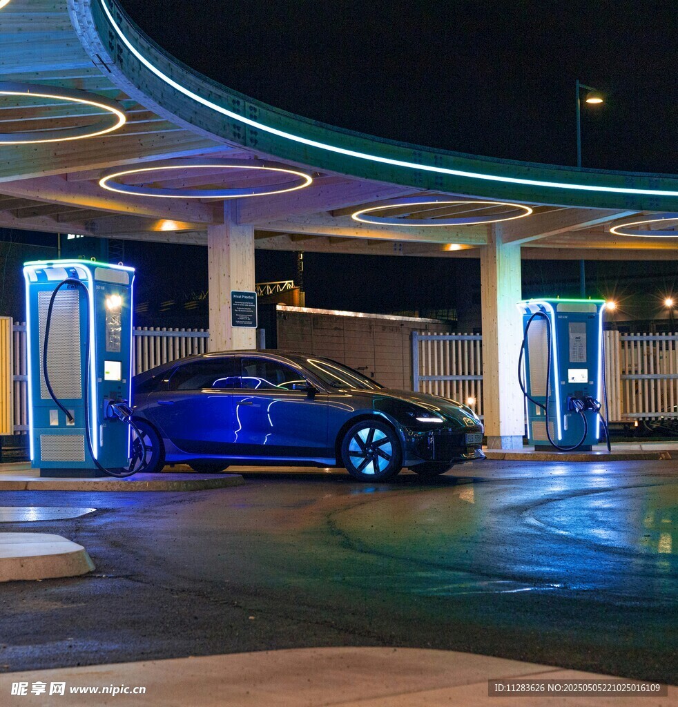 夜间充电站中的蓝色电动汽车