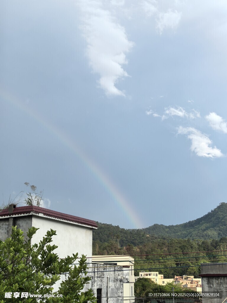 雨后现彩虹于建筑山峦间