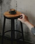手触木凳上的咖啡杯