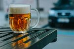 户外木桌上的一杯鲜啤酒