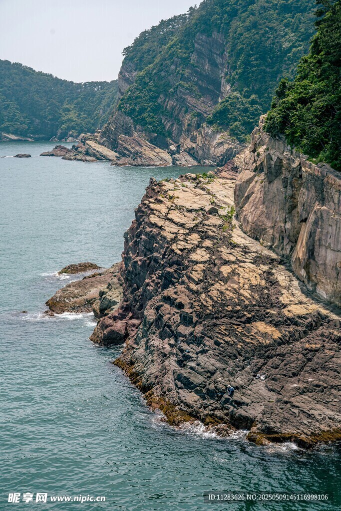 海岸边嶙峋岩石与青山