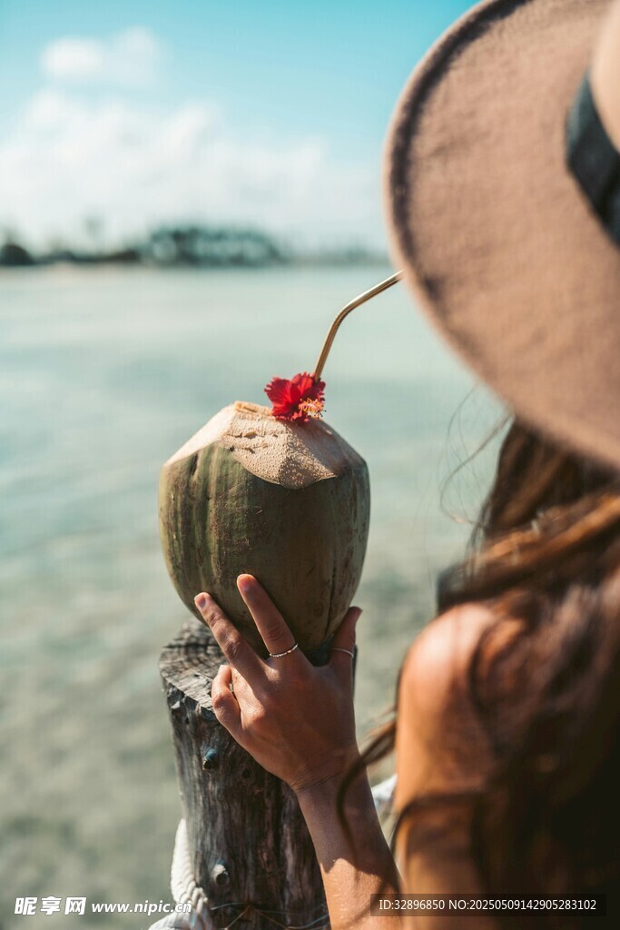 海边女子手持椰饮赏景