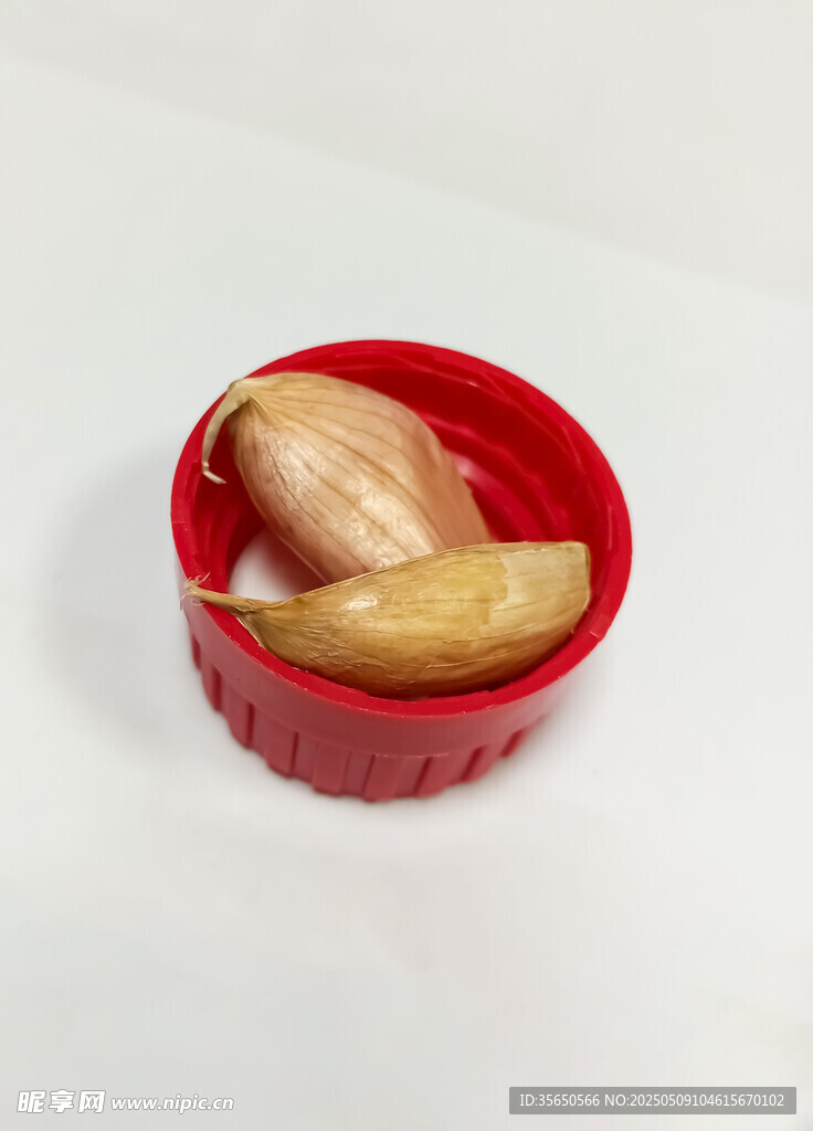 红色容器中的剥开大蒜