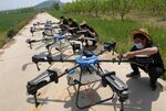 农民操作多架农用无人机