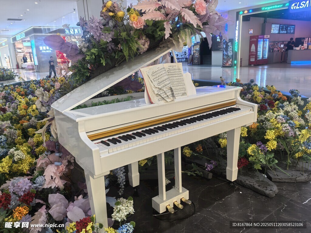 白色钢琴置于缤纷花丛中