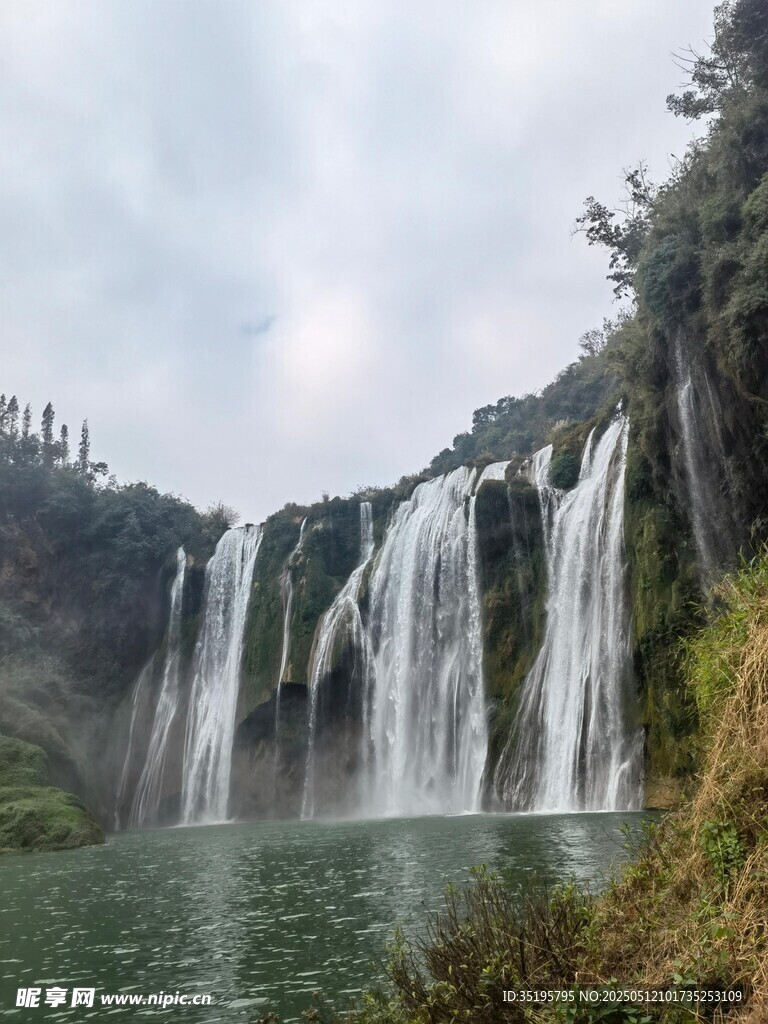 壮观瀑布下的碧绿湖水