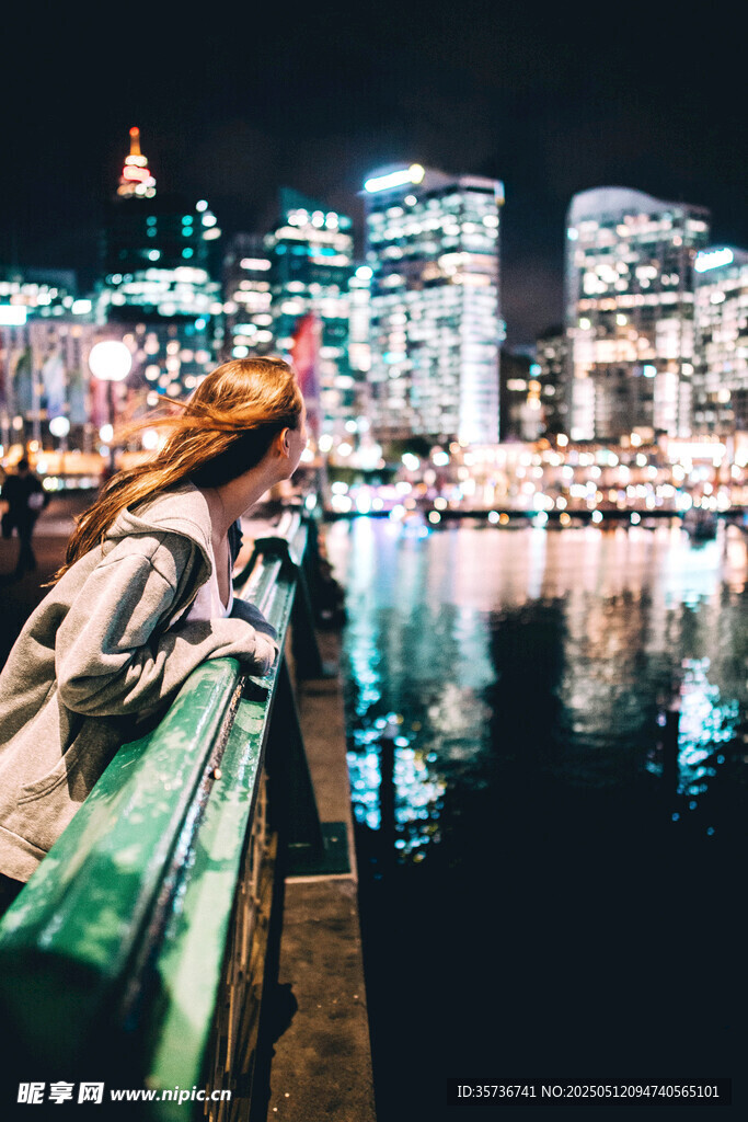 女子夜赏城市河畔璀璨夜景