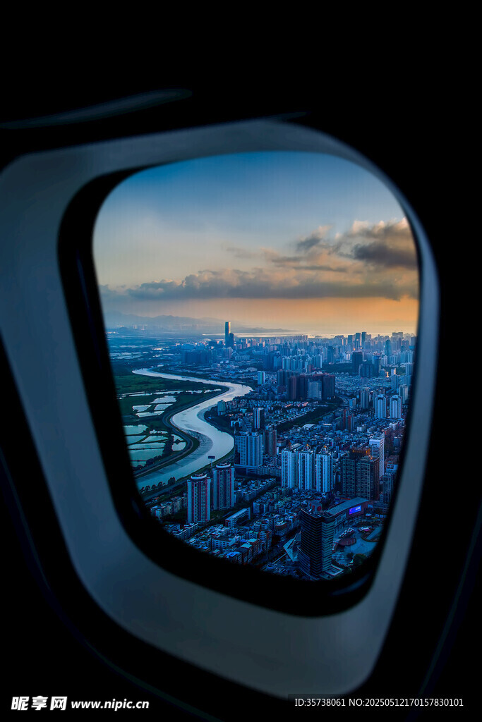 飞机舷窗中的城市黄昏景