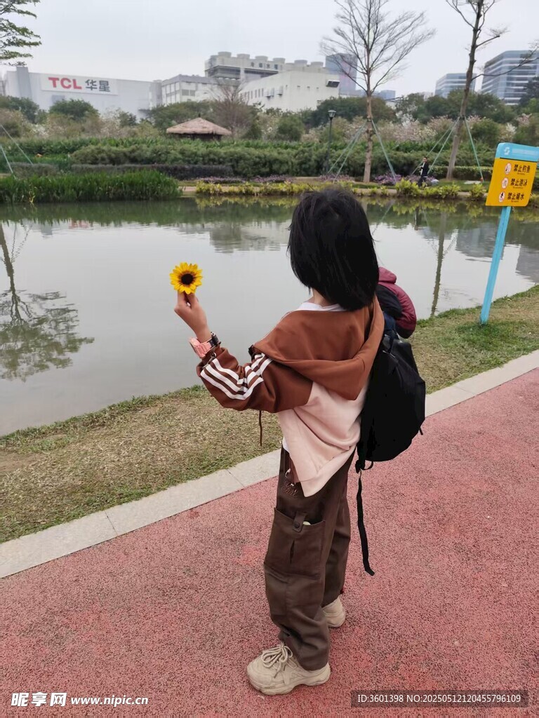 女孩公园手持花拍照留念