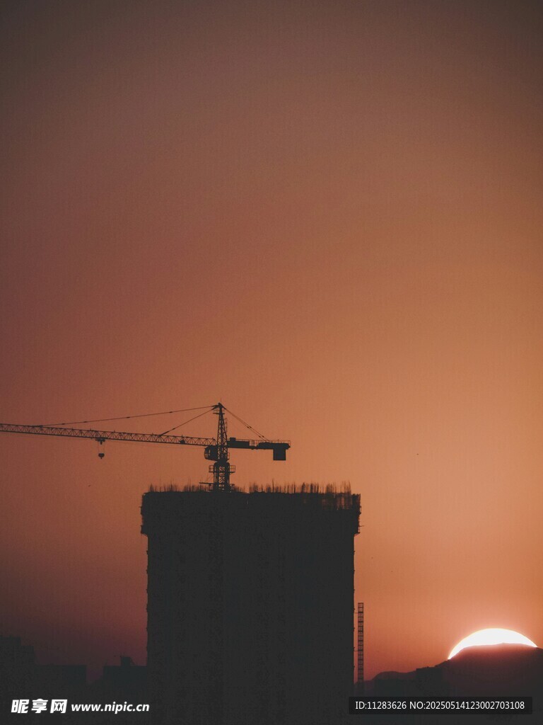 夕阳下的建筑塔吊剪影