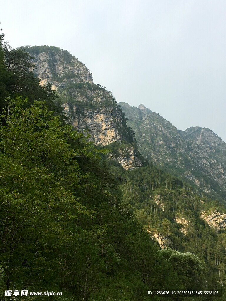 青山绿树环绕的巍峨山峰