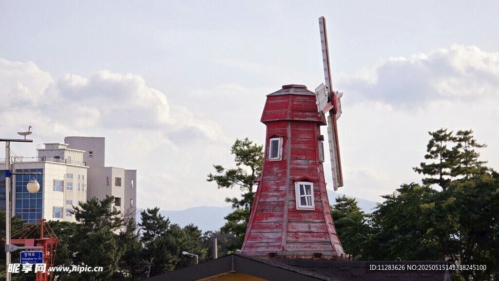 红色风车矗立城市间