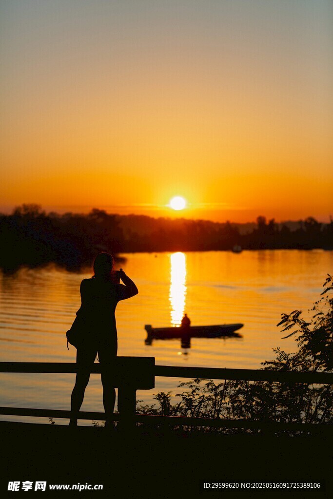 夕阳下湖畔的摄影者身影