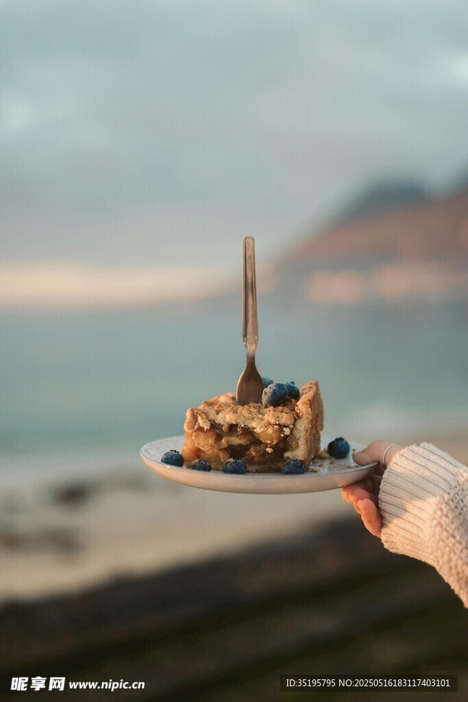 海边手持的精致美味甜点