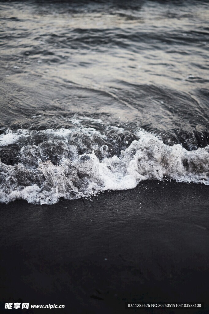 海浪轻拍黑色沙滩