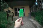 手持绿冰棍漫步户外